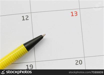 Yellow pen is placed on the calendar in the 13th day and have copy space for design in your work concept.