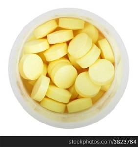 yellow pills in round plastic bottle close up isolated on white background