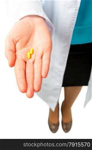 yellow pills on the palm of the doctor