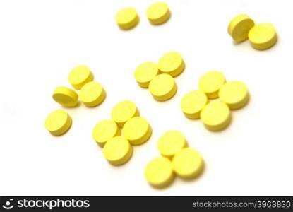Yellow pills on white background