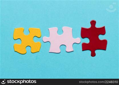 yellow pink red jigsaw puzzle piece blue textured background