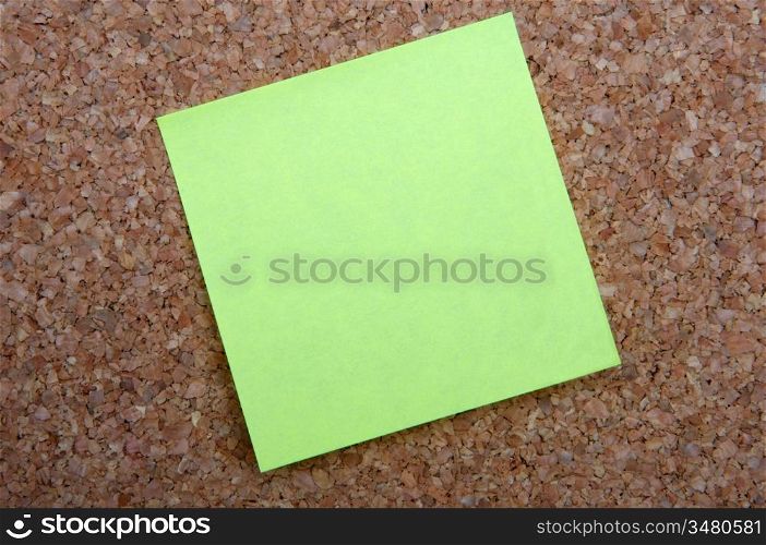 yellow post-it note on bulletin board of cork