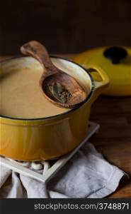 yellow pot with hot potage soup on white stand