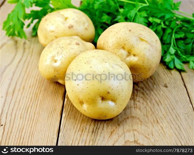 Yellow potatoes with parsley on a wooden boards background