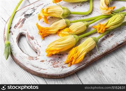 yellow pumpkin flower. Edible pumpkin flowers on white kitchen board