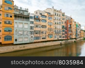 Yellow, red and orange facades of houses in Girona and Cathedral. Spain, Catalonia.