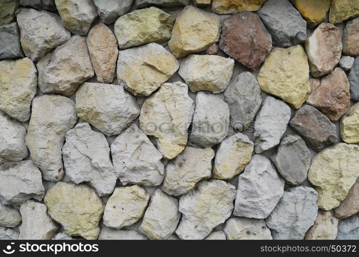 yellow, red, blue, stones and pebbles on gray wall, background, closeup