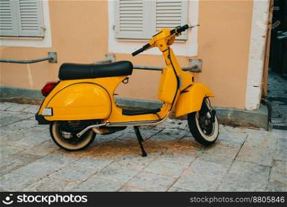 Yellow retro scooter on step near old building. Beautiful vintage design of motor bike. High quality photo. Yellow retro scooter on step near old building. Beautiful vintage design of motor bike.