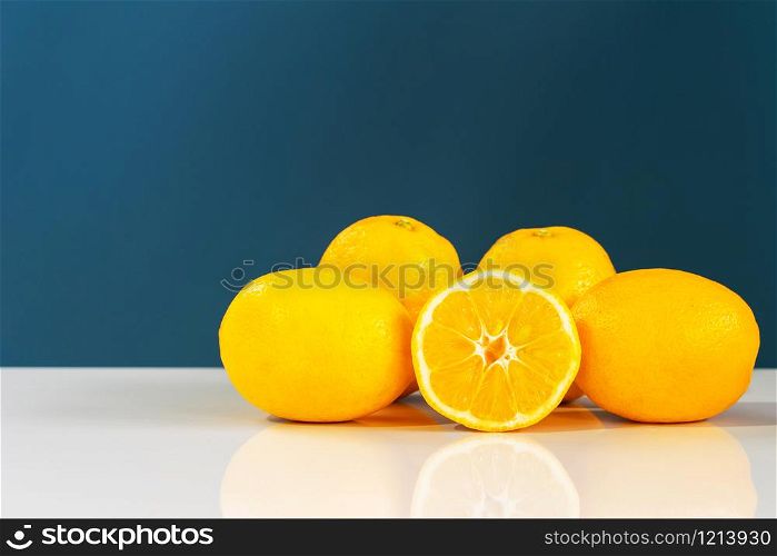 Yellow ripe lemon sliced in half juicy citrus fruit on the white table in front of the blue background wall fresh fruits
