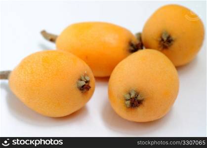 Yellow ripe loquat fruits on a white background