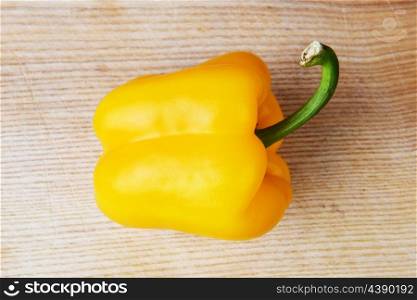 yellow ripe peppers lies on wooden cutting board