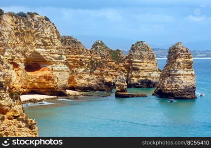 Yellow rocky coast (Ponta da Piedade, Lagos town, Algarve, Portugal). All people in boats are unrecognizable.