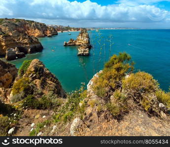 Yellow rocky coast (Ponta da Piedade, Lagos town, Algarve, Portugal). All people are unrecognizable.