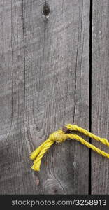 Yellow rope on old weathered wood planks.