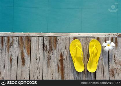 Yellow sandals by a swimming pool
