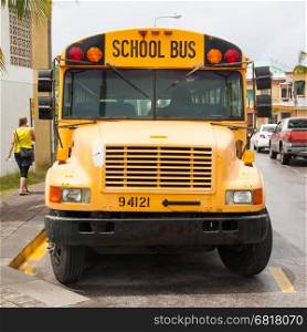 Yellow school bus parked at the side of a road