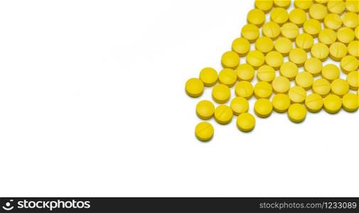 Yellow small round tablets pills on white background. Healthcare concept. Painkillers medicine. Nonsteroidal anti-inflammatory drugs (NSAIDs). Pharmaceutical industry. Painkillers or analgesic drug.
