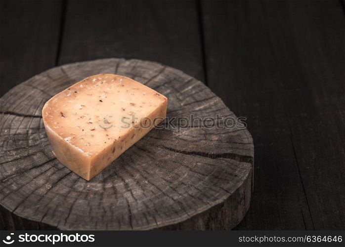 yellow smoked spicy cheese on a wooden end of a tree