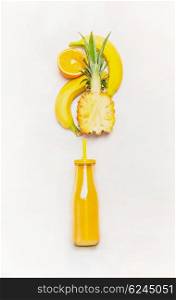 Yellow smoothie drink in bottle with straw and fruits ingredients ( banana, pineapple, orange) on white wooden background, top view