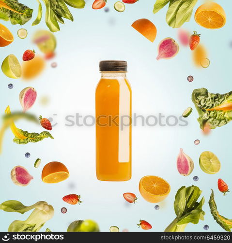 Yellow smoothie or juice bottle with flying or falling ingredients: citrus fruits, oranges and berries on light blue background. Healthy detox beverages. Detox, dieting, clean eating