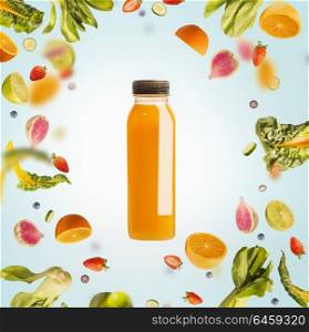 Yellow smoothie or juice bottle with flying or falling ingredients: citrus fruits, oranges and berries on light blue background. Healthy detox beverages. Detox, dieting, clean eating
