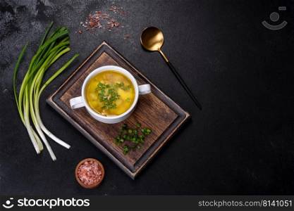 Yellow split pea soup with bacon. Space for text, top view. Fresh pea soup in bowl on black background. Cooking at home