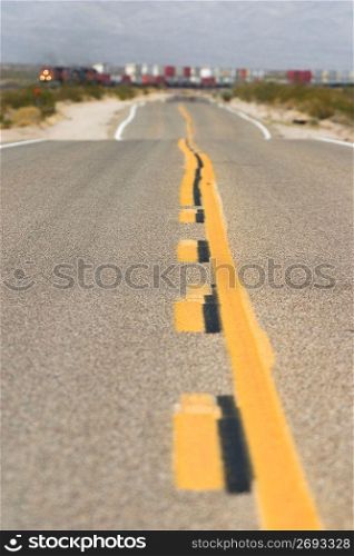 Yellow stripe down rural road, close-up