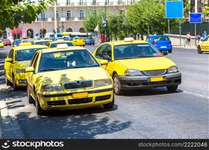 Yellow taxi in Athens in a beautiful summer day in Athens, Greece on July