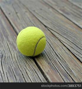 yellow tennis ball on wooden background