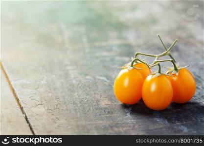 yellow tomatoes on a wooden table