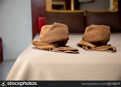 Yellow towel on bed decoration in bedroom interior, Freshly laundered fluffy towels, Towel in hotel room, Beautifully folded toiletries