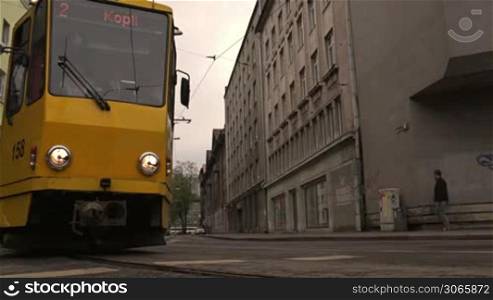 Yellow tram passing the street
