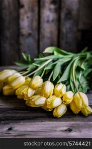 Yellow tulips on wooden background