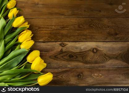 Yellow tulips on wooden background, copy space. Spring flowers. Flowers greeting. Flowers postcard. Yellow tulips on wooden background, copy space