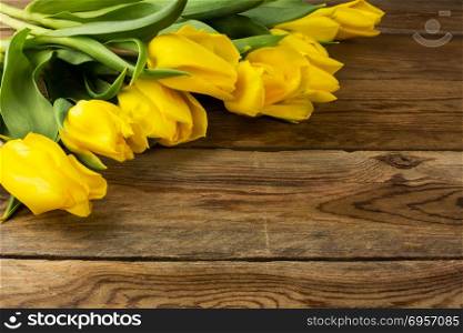 Yellow tulips on wooden background. Spring flowers. Flowers greeting. Flowers postcard. Yellow tulips on wooden background