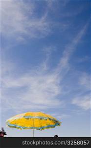 Yellow umbrella against blue sky
