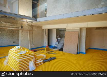 yellow underfloor heating posed in a under construction building