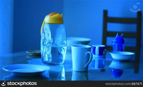 Yellow water jar and dishes on the table