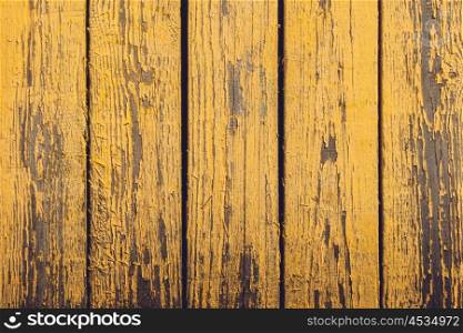Yellow wooden planks with peeling paint and grunge look