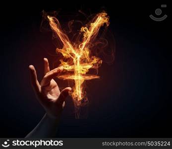 Yen currency symbol. Burning yen sign in businessman palm on dark background