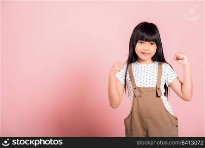 Yes   Asian little kid 10 years old celebrating great success with arms raised at studio shot isolated on pink background, Happy and excited child girl positive smiling cheerful