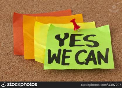 yes we can - motivational slogan on a stack of sticky notes posted on cork bulletin board