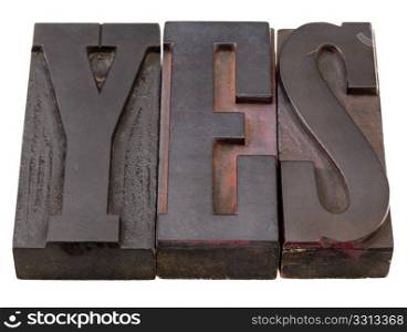 yes - word in antique wooden letterpress printing blocks, stained by dark color inks, isolated on white