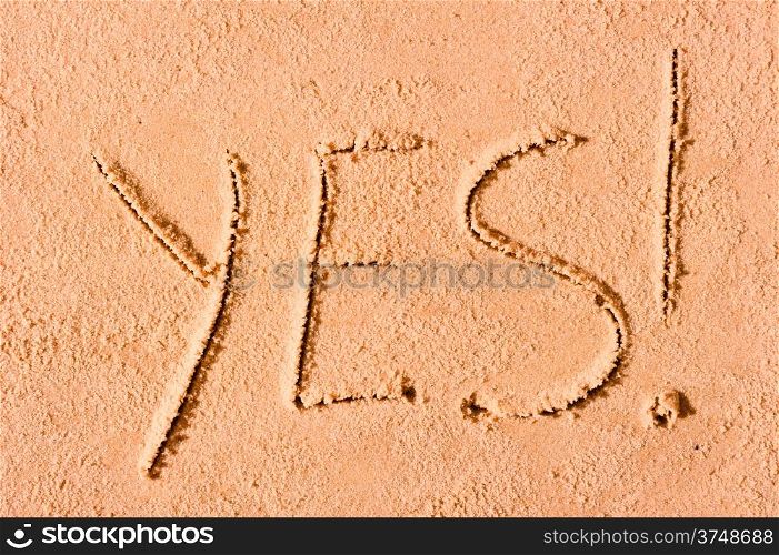 YES written on wet sand at the sea