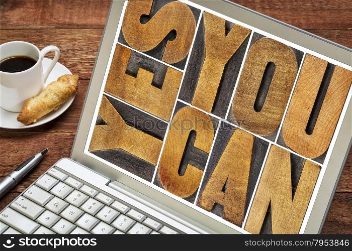 Yes you can - motivational slogan - a text in vintage letterpress wood type printing block on a laptop screen with a cup of coffee
