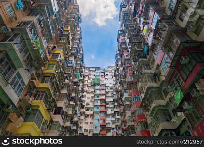 Yick Fat Building, Quarry Bay, Hong Kong Downtown. Residential area in old crowded apartments. High-rise building, skyscraper with facade windows of architecture in urban city at noon with blue sky.