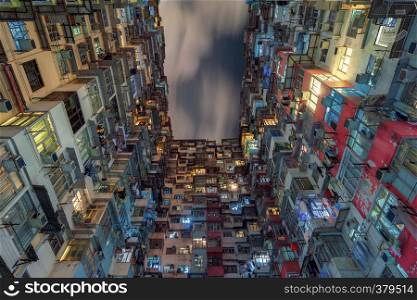 Yick Fat Building, Quarry Bay, Hong Kong. Residential area in old apartment. High-rise building, skyscraper with windows of architecture in urban city at night.