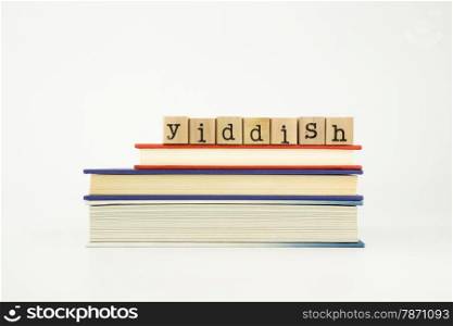 yiddish word on wood stamps stack on books, foreign language and translation concept