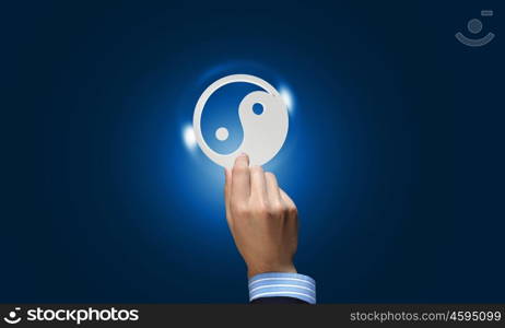 Yin yang icon. Close up of human hand with yin yang concept icon