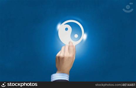 Yin yang icon. Close up of human hand with yin yang concept icon